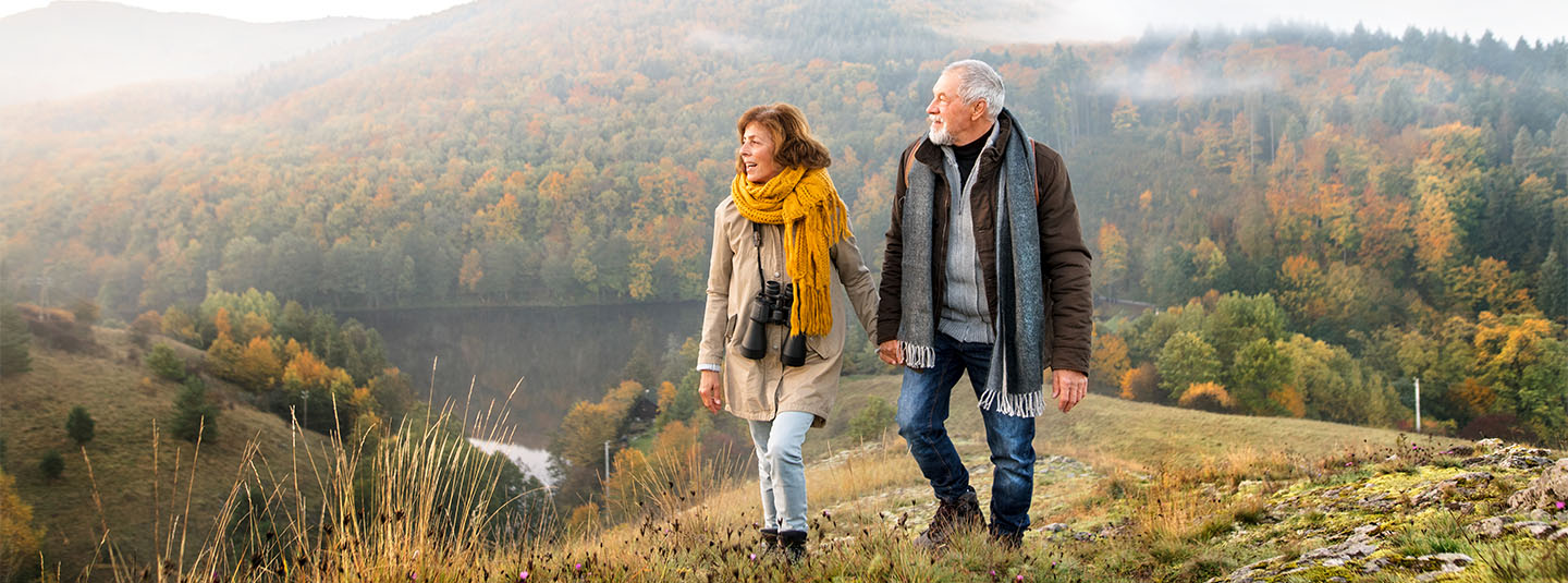 Older couple walking on top of hill